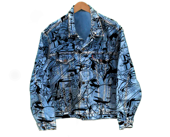 Une veste en jean couverte de dessins de comics en noir et blanc, sur un cintre