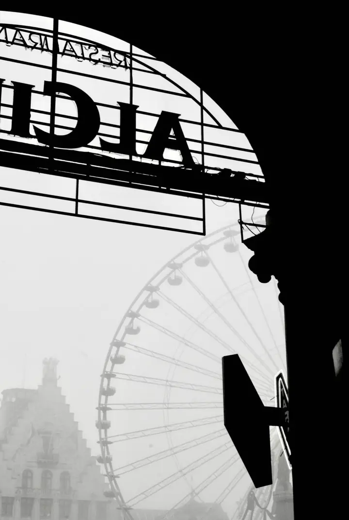 Une grande roue vue en contre-jour, sous l’arche d’une enseigne