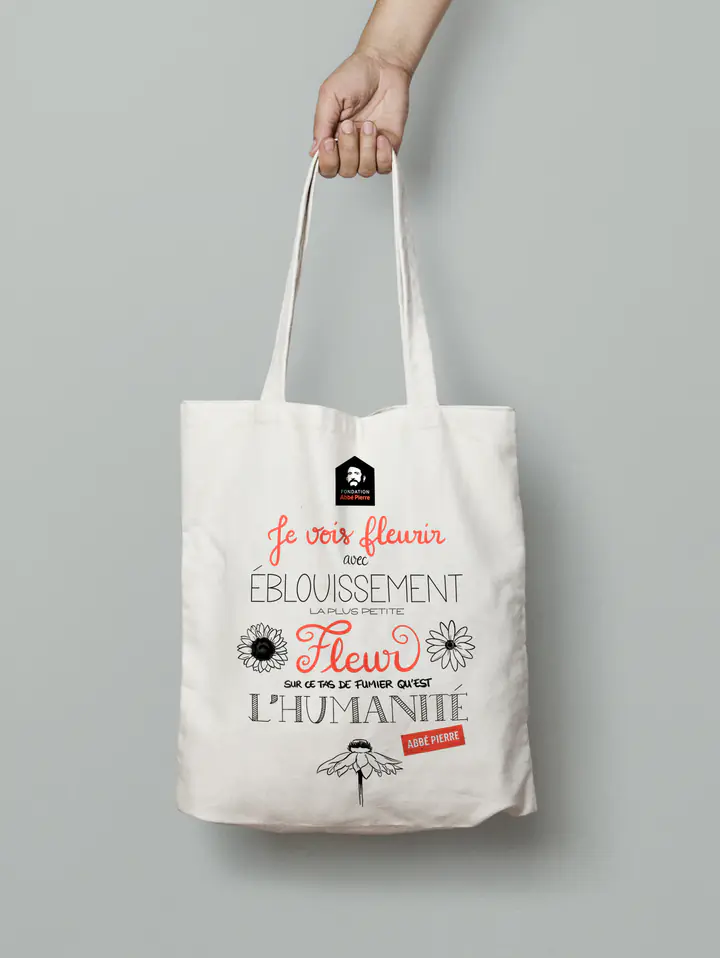 Un tote bag orné d’une citation calligraphiée et de fleurs