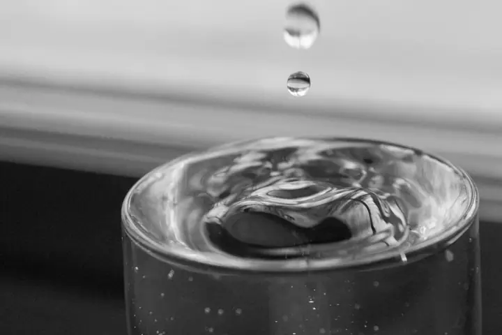 Des gouttes tombent dans un verre d’eau