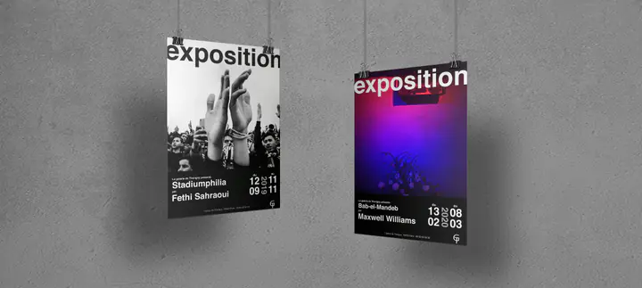 Deux affiches d’exposition de la galerie suspendues devant un mur gris