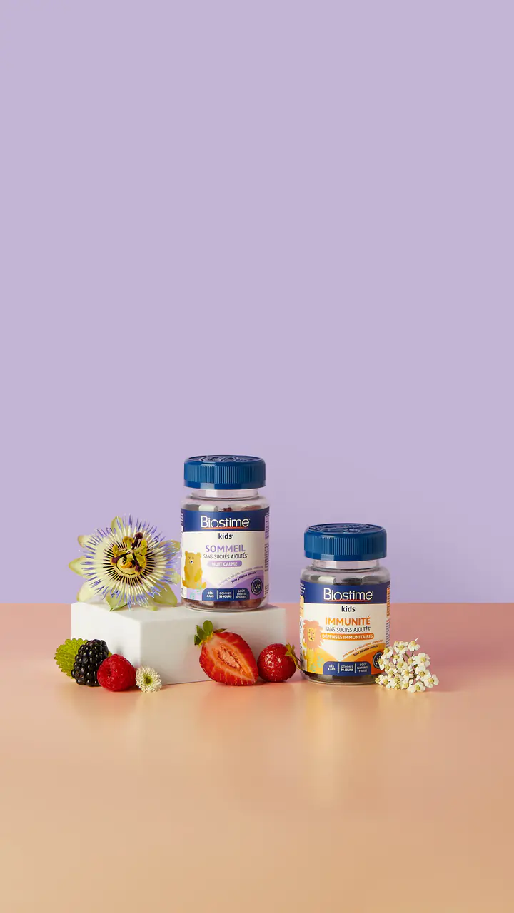 Deux piluliers Biostime sur des cubes, entre fleurs de la passion et fruits rouges