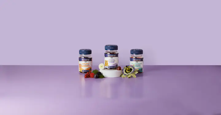 Trois piluliers Biostime sur fond mauve