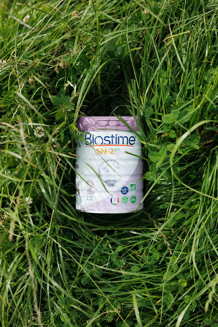 Une boîte de lait Biostime dans l’herbe haute