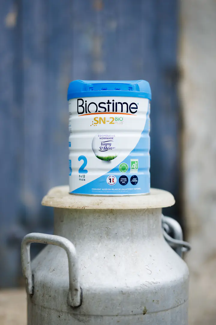 Une boîte de lait Biostime sur un bidon à lait en métal